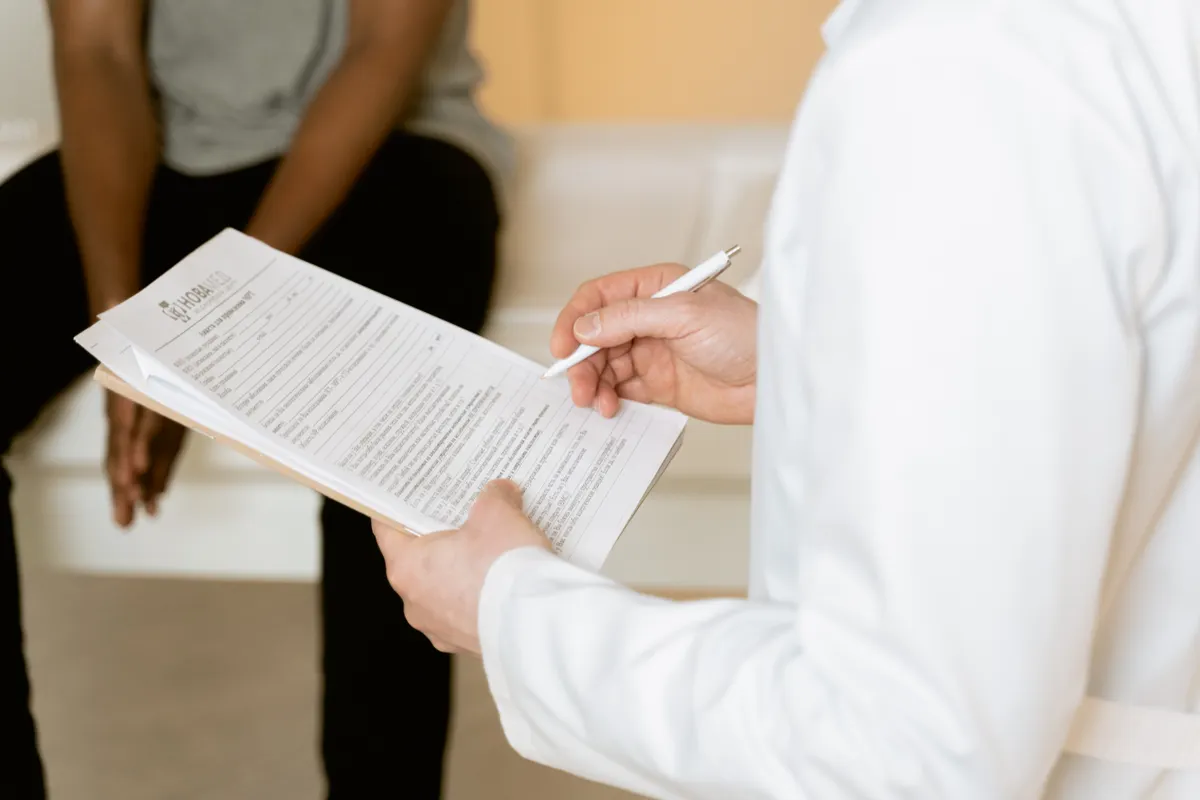 Close-up of a medical professional reviewing a written plan with a patient